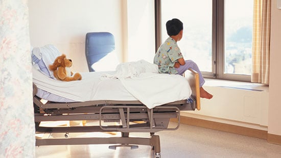 Hôpitaux et centres chirurgicaux - garçon sur son lit d'hôpital regardant par la fenêtre