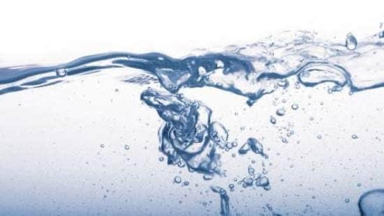 Close up of water swirling and bubbling on a white background.