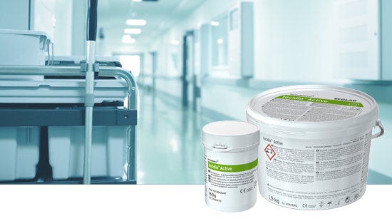 Hospital corridor with a cleaning cart and surface disinfectant containers in the foreground.